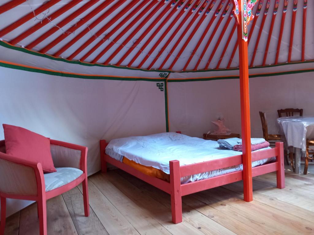 une chambre avec un lit et deux chaises dans une pièce dans l'établissement Yourte en pleine nature, à Dampierre