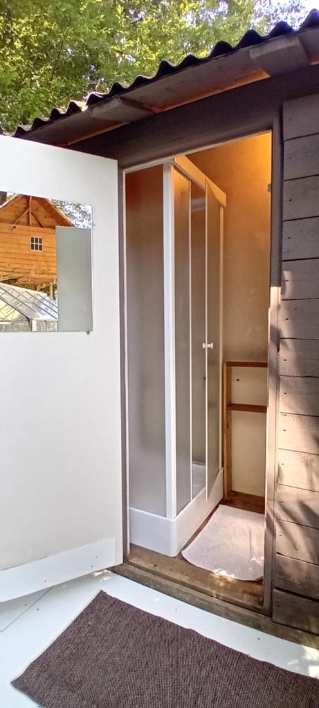 une petite porte en verre dans une maison dans l'établissement Yourte en pleine nature, à Dampierre