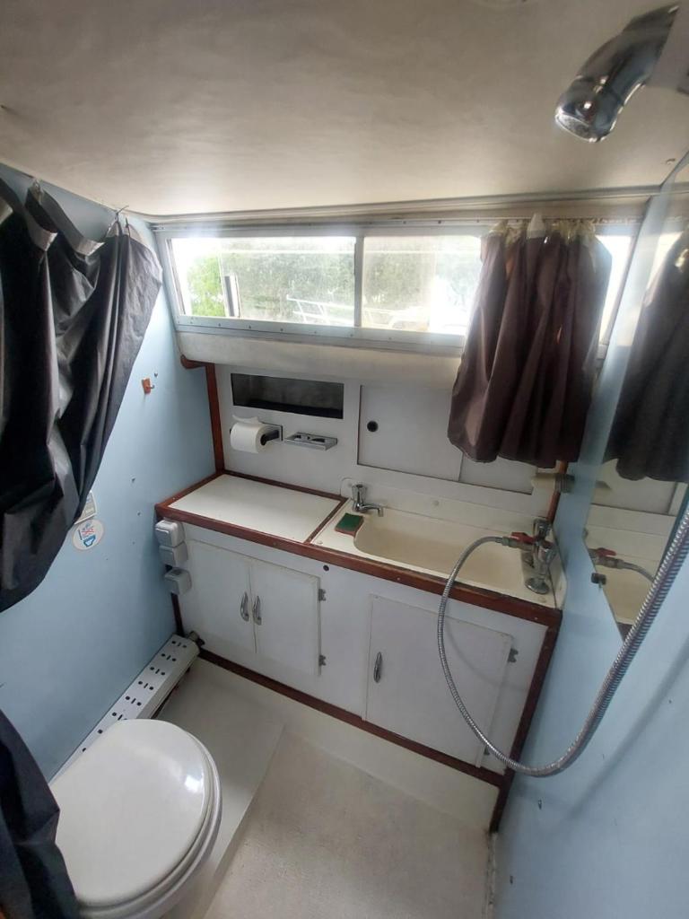 une petite salle de bain avec toilettes et lavabo dans l'établissement Escapade en Bateau VINTAGE terrasse mini spa option payante, à Seurre