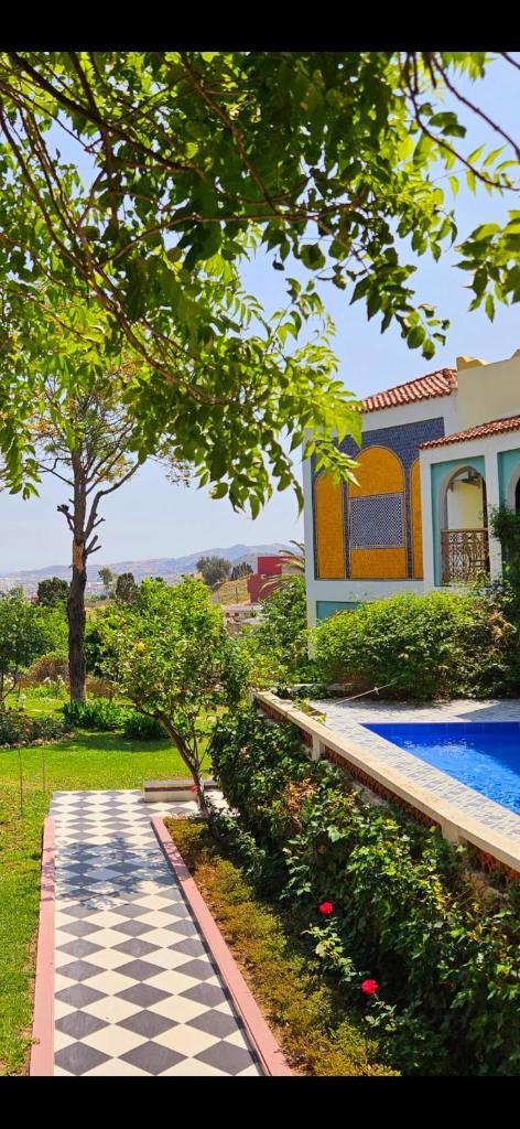 un jardin avec une piscine et une maison dans l'établissement Riad Dar Achaach, à Tetouan
