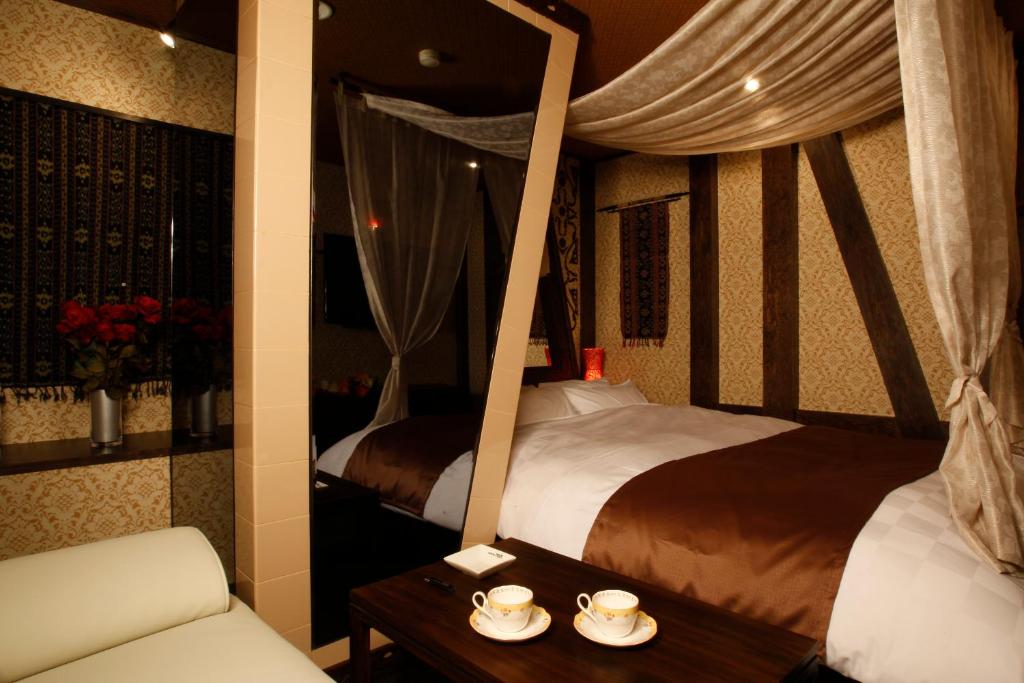 - une chambre avec deux lits, un canapé et une table dans l'établissement HOTEL K's ABA Adult Only, à Nagoya