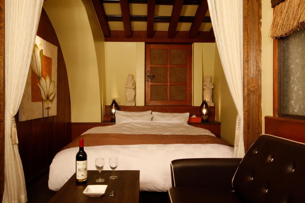 - une chambre avec un lit et deux verres de vin dans l'établissement HOTEL K's ABA Adult Only, à Nagoya