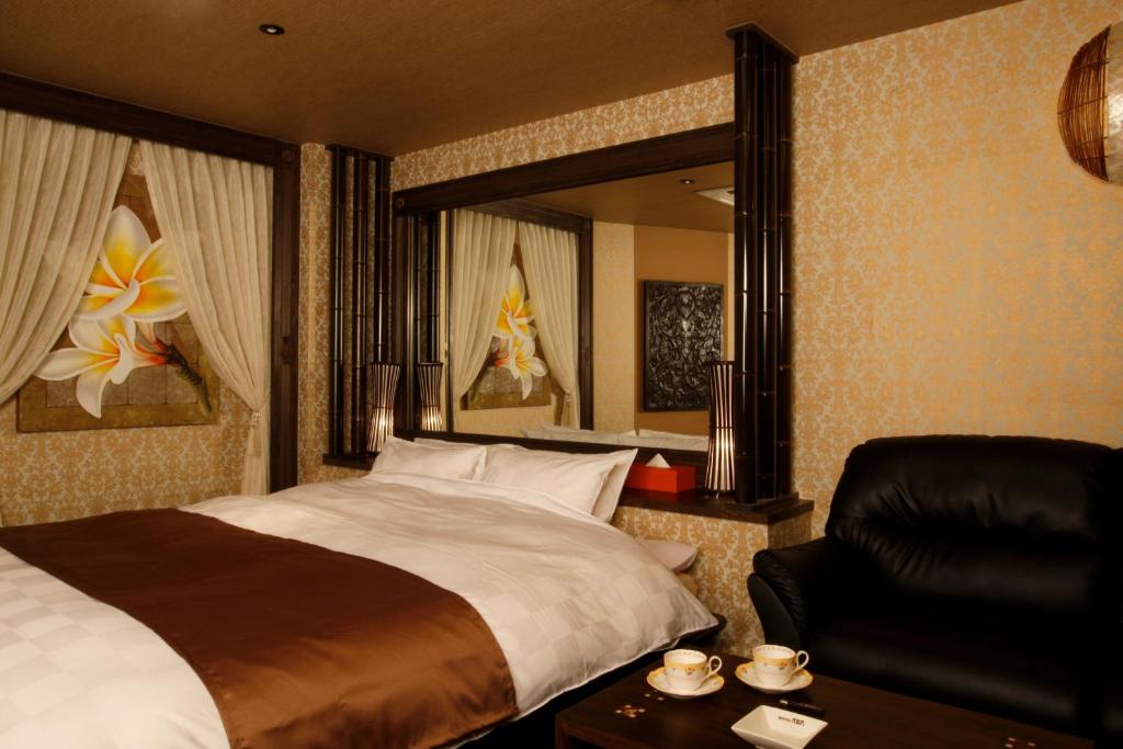 une chambre d'hôtel avec un lit, une chaise et un miroir dans l'établissement HOTEL K's ABA Adult Only, à Nagoya 10 autres photos