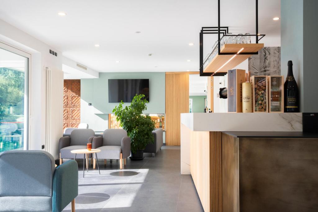 - un salon avec des chaises et une table avec une bouteille de vin dans l'établissement Panoramic Hotel San Carlo Ledro, à Ledro