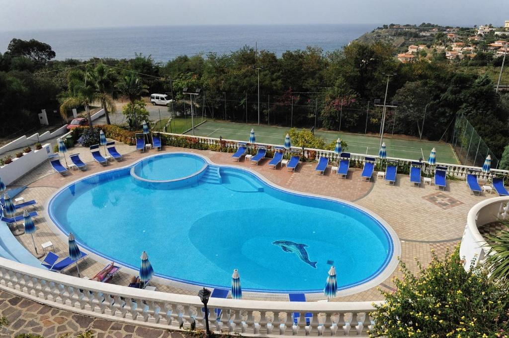 une piscine avec un dauphin au milieu dans l'établissement Villaggio Pineta Petto Bianco, à Capo Vaticano