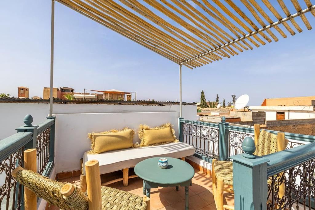 d'une terrasse avec un canapé et des chaises sur un balcon. dans l'établissement Riad YANNIS, à Marrakech