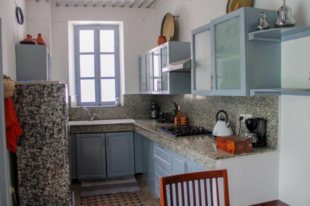 une cuisine avec des armoires bleues et un évier dans l'établissement Riad Dar, à Essaouira