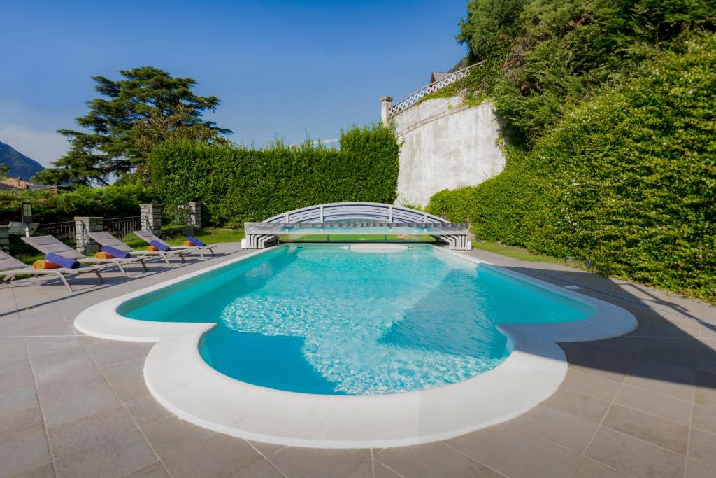 - une piscine d'eau bleue et des chaises dans l'établissement Luxury Villa Laglio, à Laglio