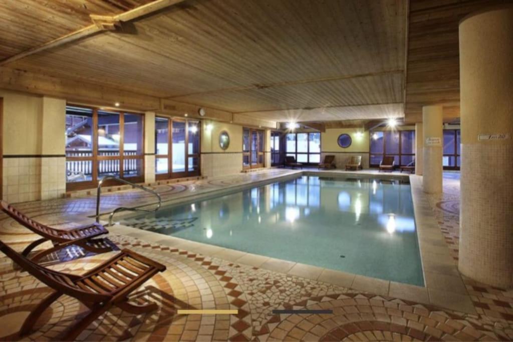 - une grande piscine avec banc dans un bâtiment dans l'établissement Duplex 170m2 avec terrasse vue domaine skiable ARCS2000, à Arc 1950