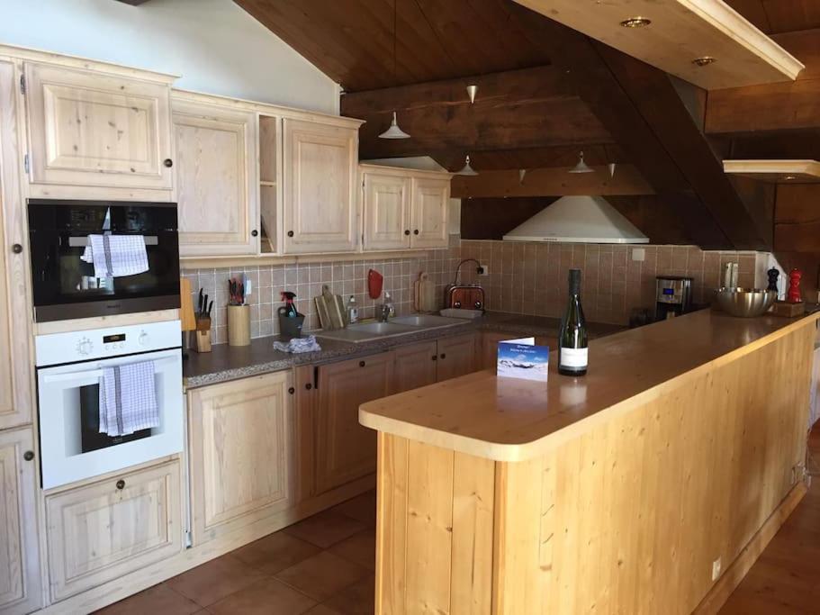 une cuisine avec des armoires en bois et un comptoir dans l'établissement Duplex 170m2 avec terrasse vue domaine skiable ARCS2000, à Arc 1950