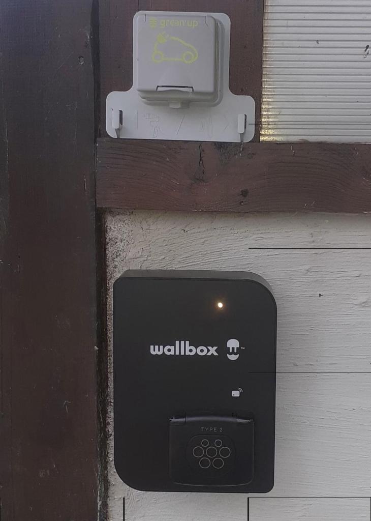 une boîte aux lettres sur un mur avec un panneau portefeuille dans l'établissement Gîtes Tré Le Grenier, à Les Moussières