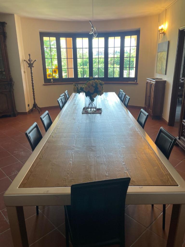 une grande table en bois dans une pièce avec des chaises dans l'établissement Villa Jilla, à Calosso