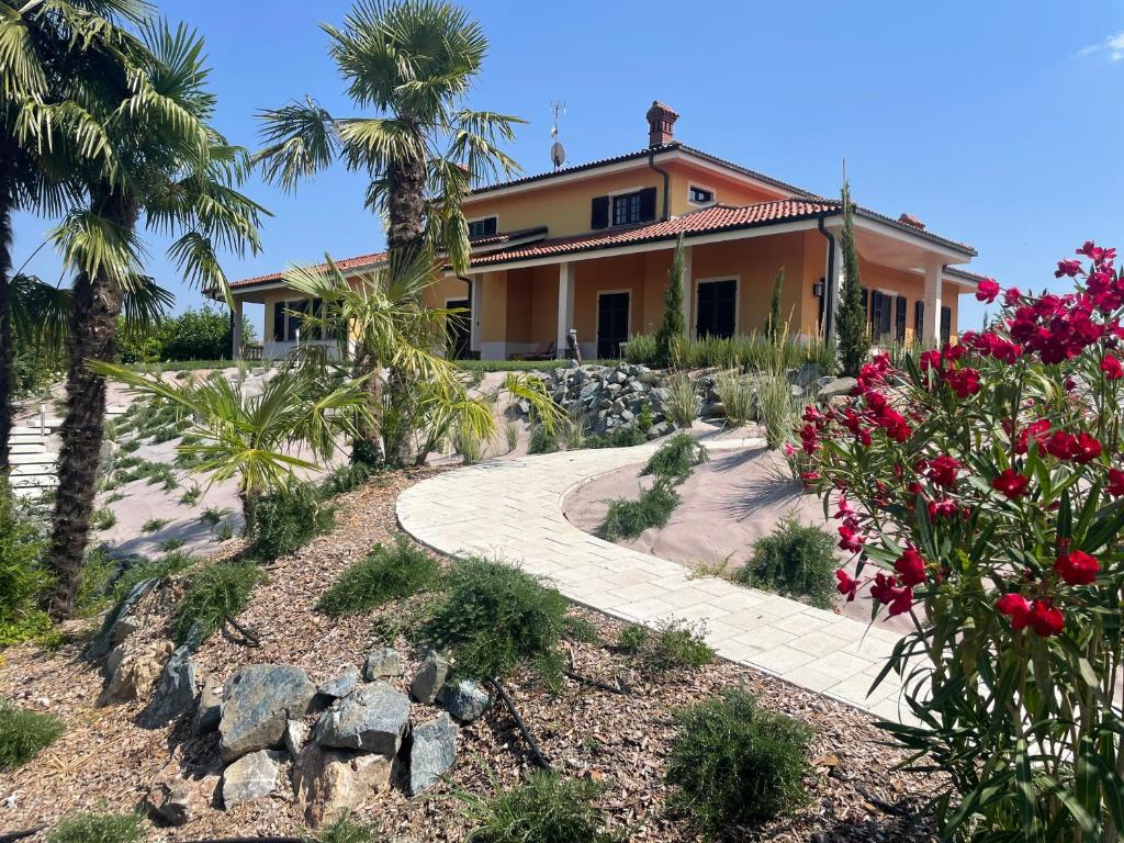 une maison avec des palmiers et une passerelle dans l'établissement Villa Jilla, à Calosso