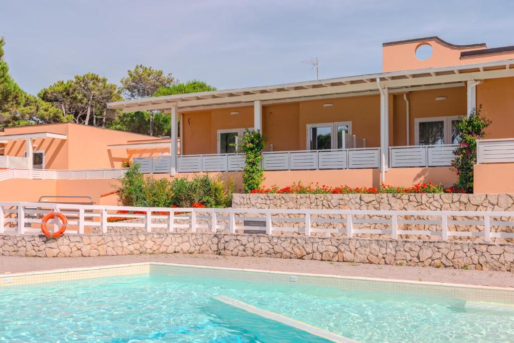 une villa avec piscine devant une maison dans l'établissement Tuscany Hotel Alle Dune, à Marina di Castagneto Carducci