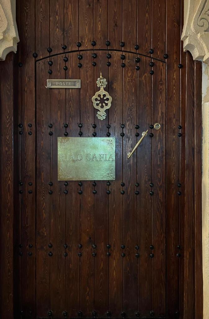 une grande porte en bois avec un panneau. dans l'établissement Riad Safia, à Rabat