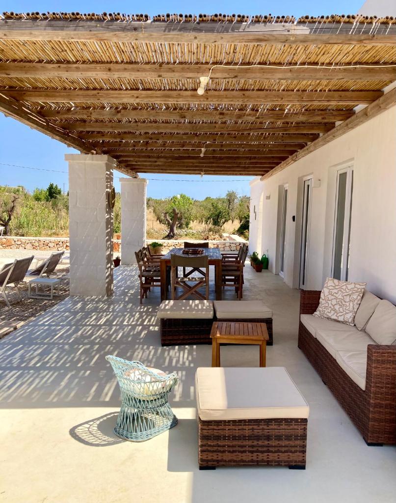 un patio avec un canapé, une table et des chaises dans l'établissement Villa Pupetta Ostuni 4 bedrooms 4 bathrooms - swimming pool, à Ostuni