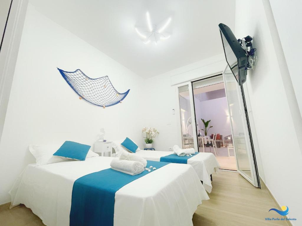 une chambre avec trois lits avec une caméra sur le mur dans l'établissement VILLA PERLA del SALENTO con piscina, à Lido Marini