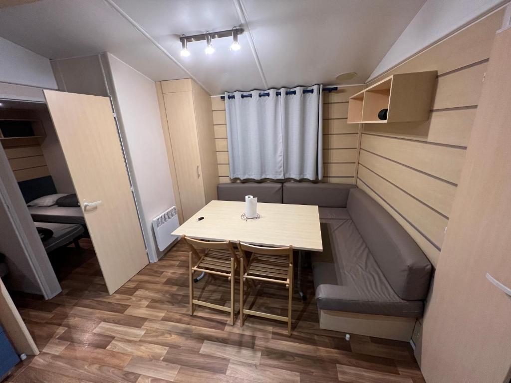 Cette petite chambre comprend une table et un canapé. dans l'établissement mobil home, à Saint-Chéron