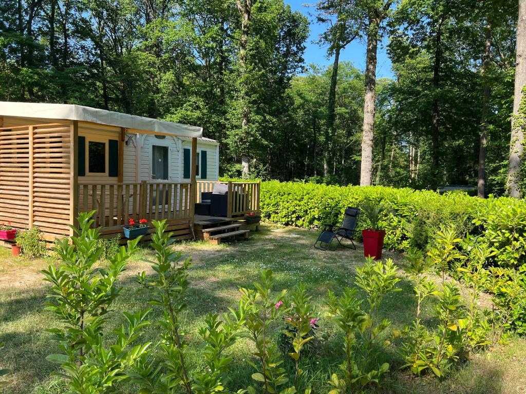 une petite maison dans une cour avec un jardin dans l'établissement mobil home, à Saint-Chéron