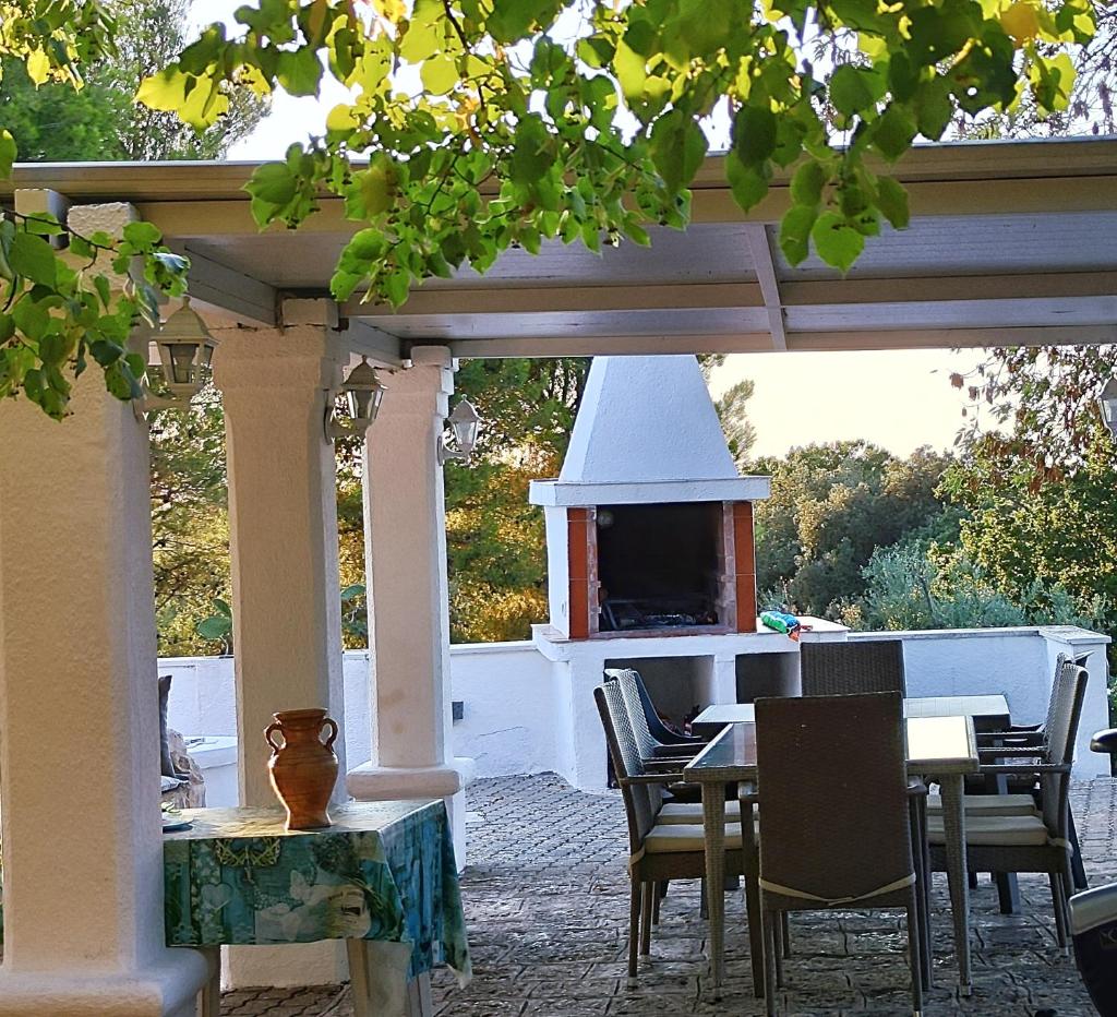 un patio avec une table, des chaises et une cheminée dans l'établissement Trullocarluccio, à Monopoli