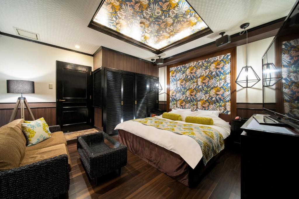 une chambre avec un grand lit et un canapé dans l'établissement Hotel Salle de bain, à Osaka