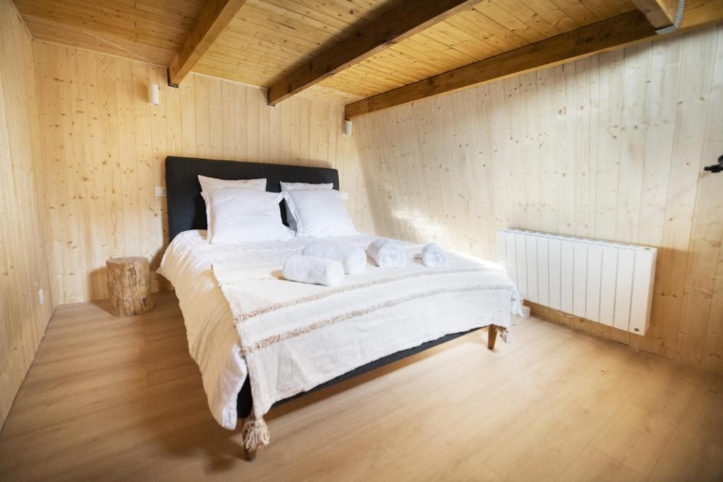 une chambre avec un grand lit avec des serviettes dessus dans l'établissement Bel appartement type chalet avec balnéo et jardin, à Gréolières