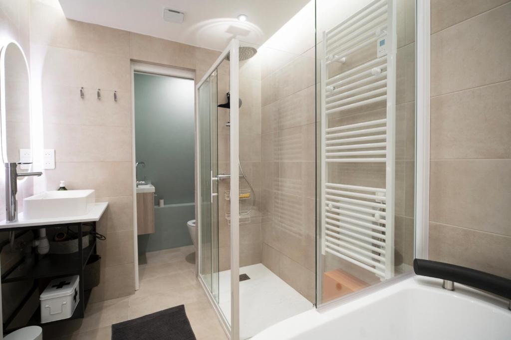 une salle de bain avec douche et lavabo dans l'établissement Bel appartement type chalet avec balnéo et jardin, à Gréolières