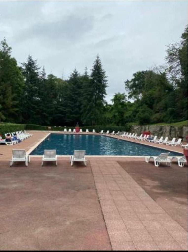 une piscine avec des chaises longues et un groupe dans l'établissement Mobil home, à Saint-Chéron 2 autres photos