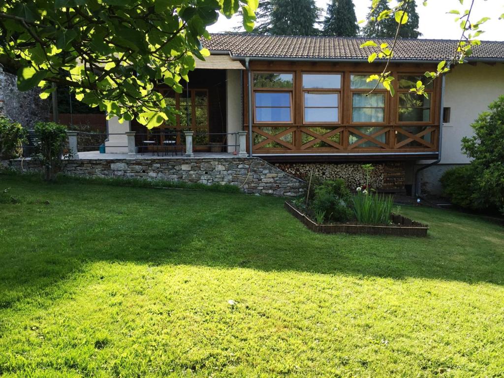une maison avec une terrasse couverte et une cour herbeuse dans l'établissement Corte Villa Donati, à Cissano