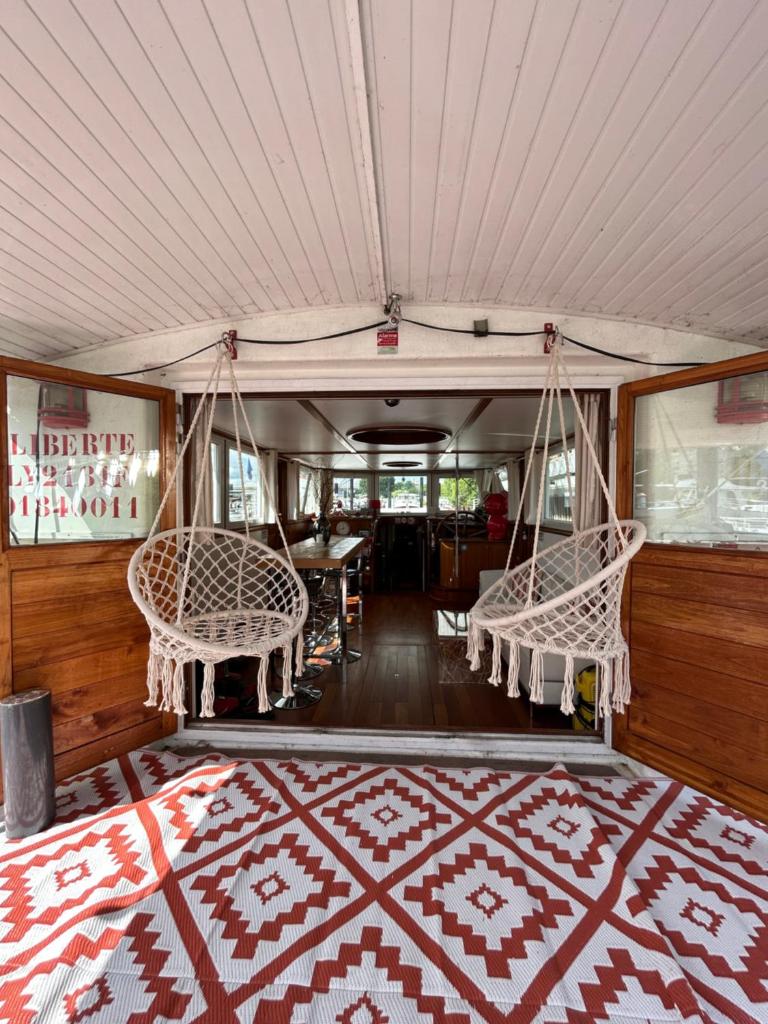 une chambre avec deux chaises, un lit et un tapis dans l'établissement Péniche Design 115m2 Port Privé Vue Seine à 15min de Paris, à Asnières-sur-Seine