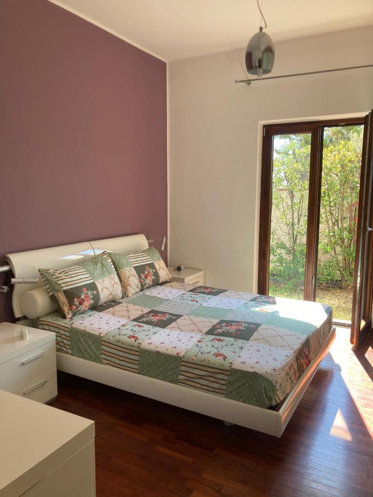 une chambre avec un lit et une grande fenêtre dans l'établissement Villa sul mare con piscina privata, à Bisceglie