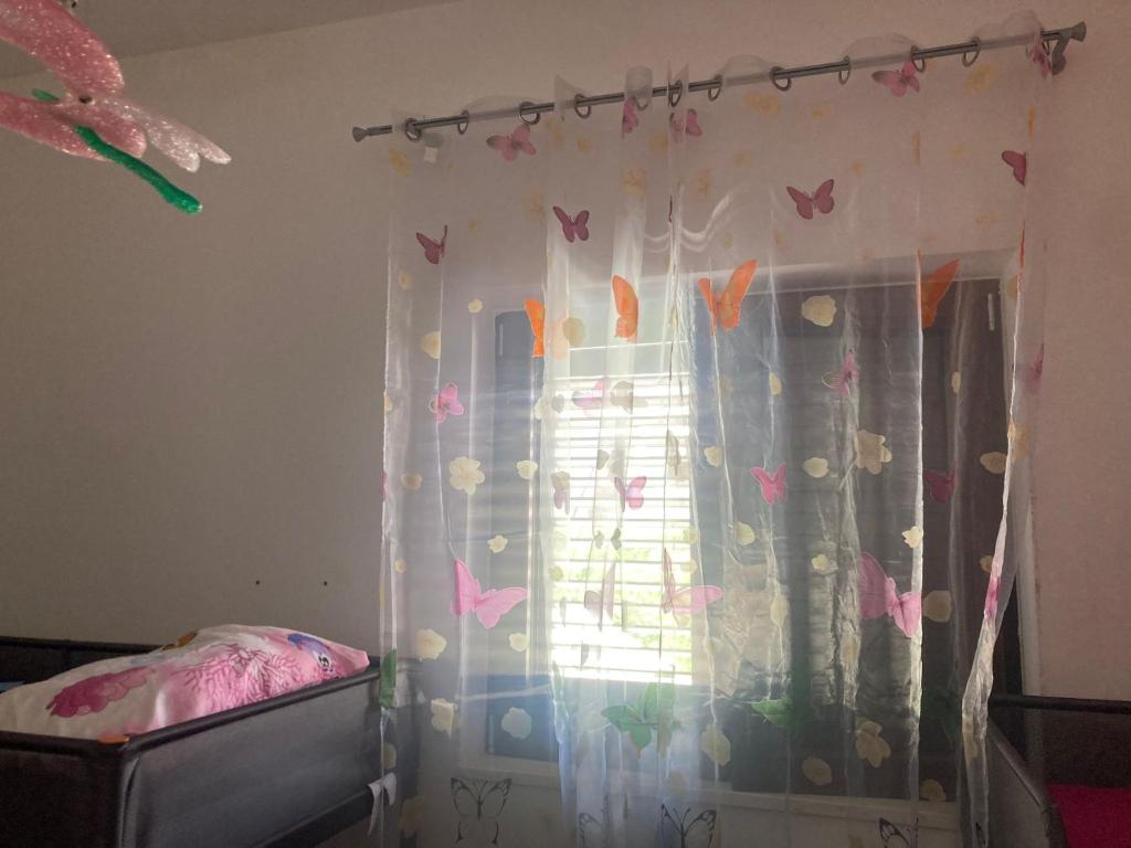 - une chambre dotée d'une fenêtre avec des papillons sur le mur dans l'établissement Villa sul mare con piscina privata, à Bisceglie