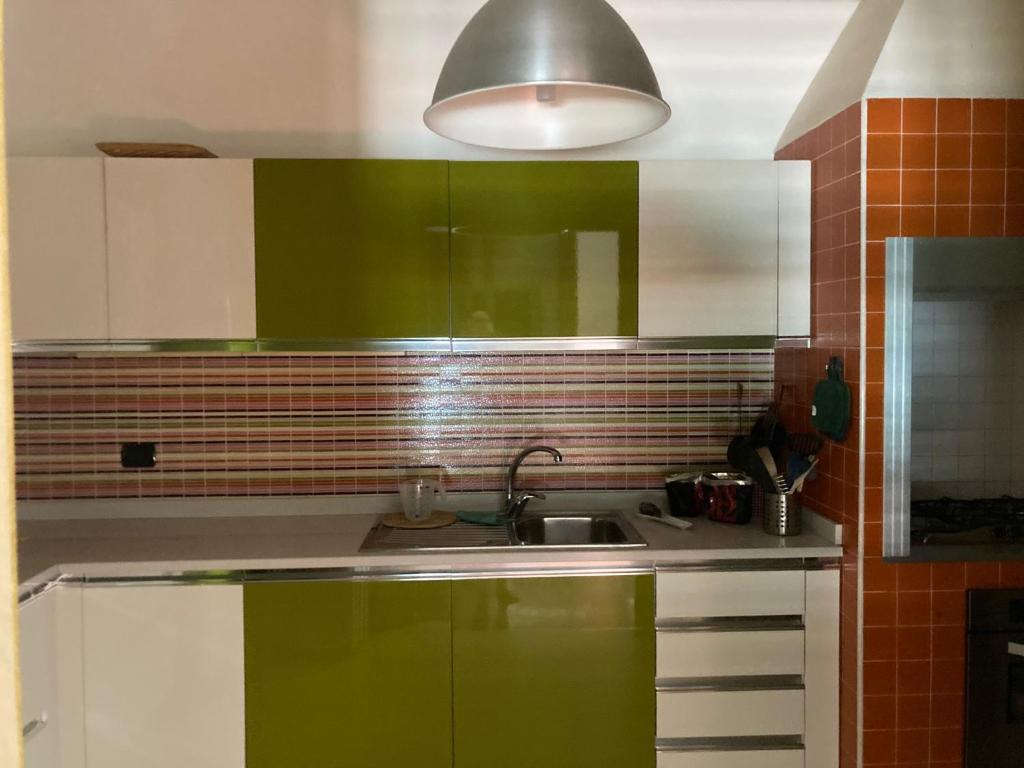 - une cuisine avec des placards verts et blancs et un évier dans l'établissement Villa sul mare con piscina privata, à Bisceglie