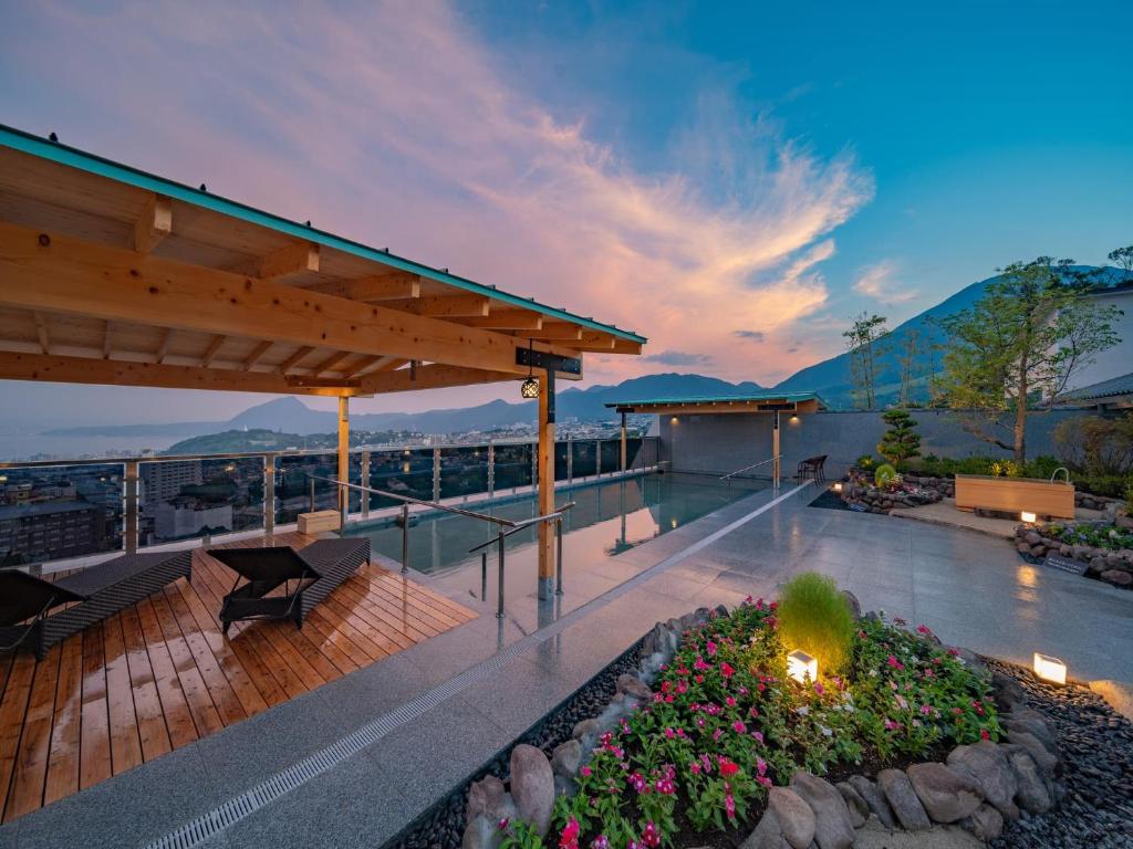 une terrasse avec un banc et des fleurs dans un bâtiment dans l'établissement Kannawaen, à Beppu