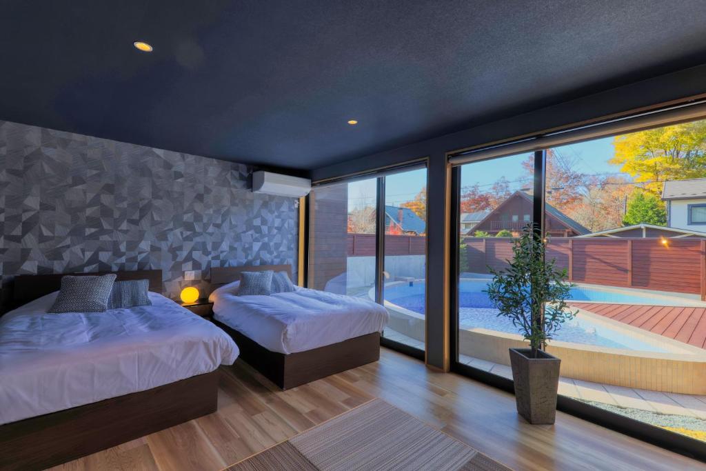 une chambre avec deux lits et une grande fenêtre dans l'établissement Private Villa Glampimg 富士山中湖, à Yamanakako
