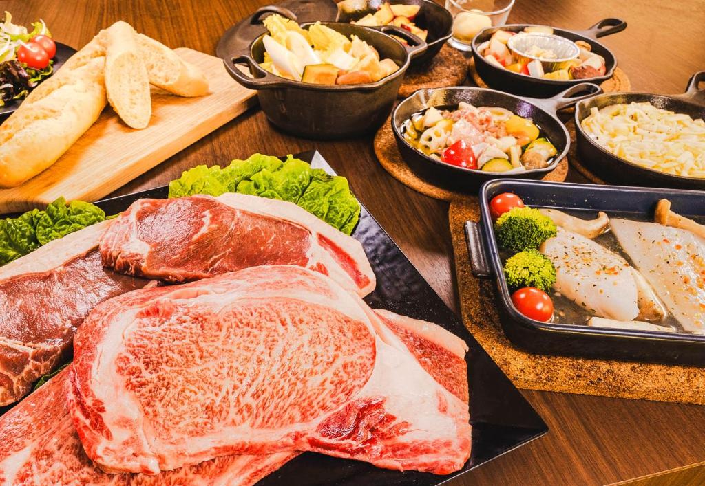 une table recouverte de différents types de viande et de légumes dans l'établissement Private Villa Glampimg 富士山中湖, à Yamanakako