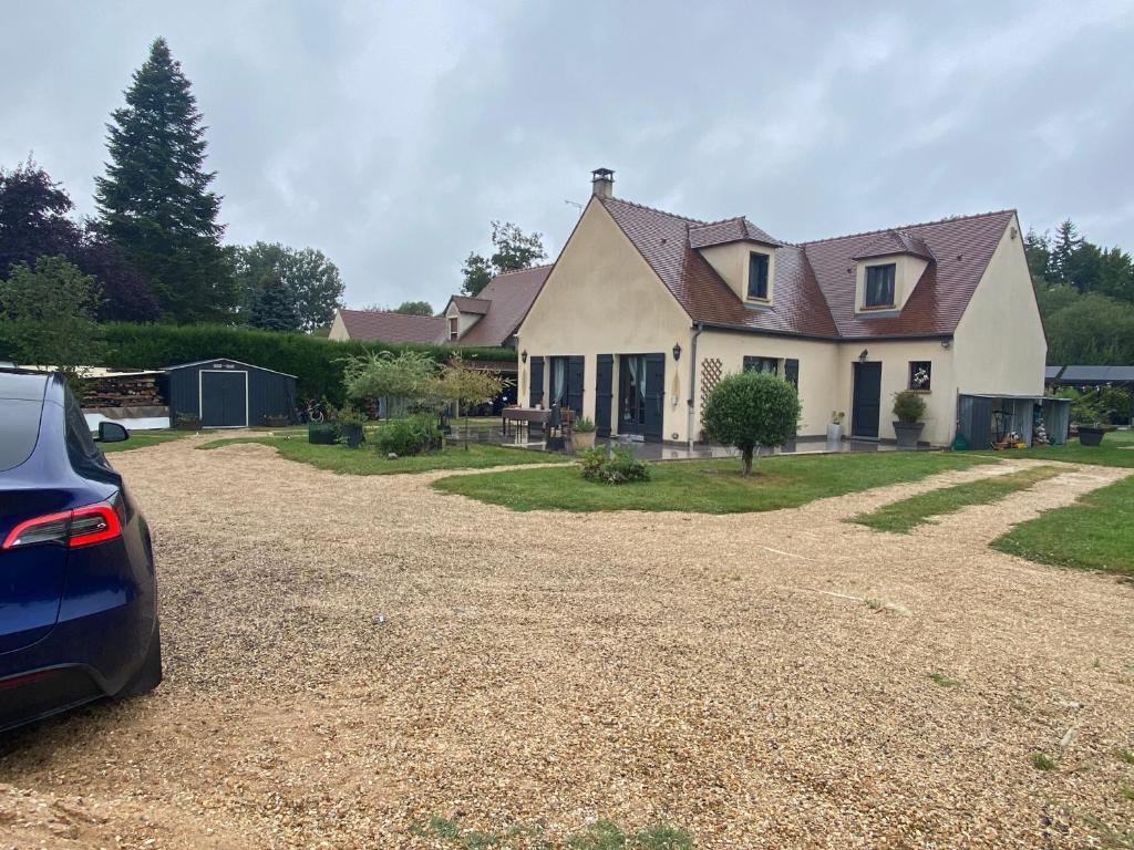 une maison avec une voiture garée devant dans l'établissement Camping-car au Charme de la Forêt Circuit des 25 Bosses, à Le Vaudoué