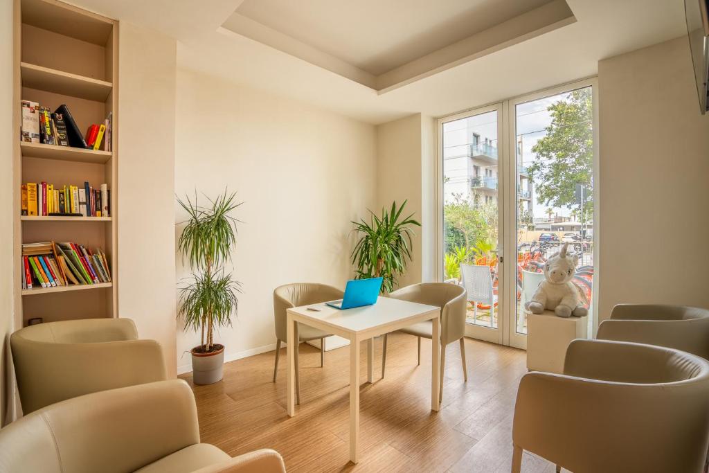 une chambre avec des chaises et une table munie d'un ordinateur portable. dans l'établissement Hotel Amicizia, à Rimini