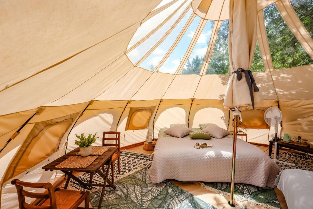 une chambre dans une tente avec un lit et une table dans l'établissement ECO CEIBA, à Busque