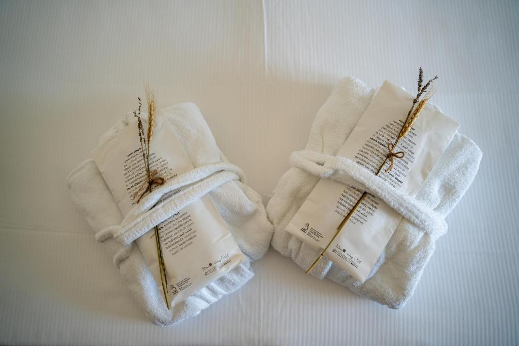 deux serviettes blanches avec un livre dessus dans l'établissement Grand Hotel Excelsior, à Senigallia