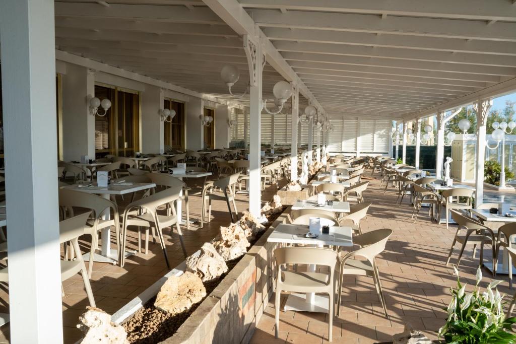 un restaurant avec des tables et des chaises sur une terrasse dans l'établissement Grand Hotel Excelsior, à Senigallia