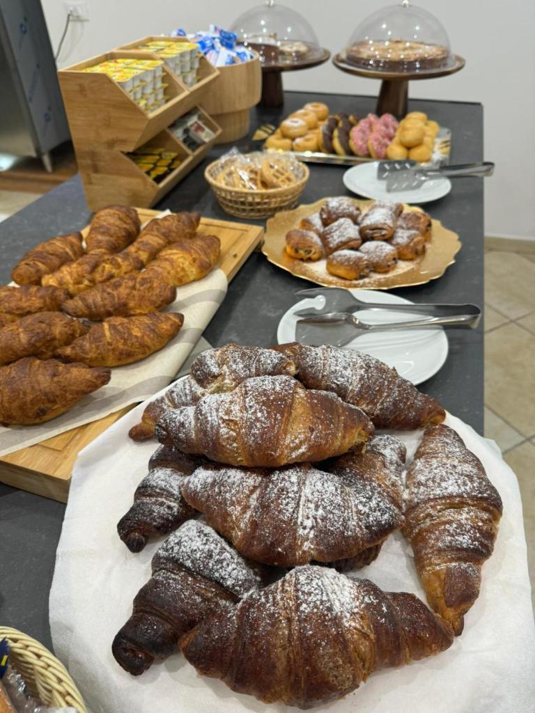 - une table avec de nombreux types de pains et de pâtisseries dans l'établissement B&B Marina Sleep And Ship, à Rodi Garganico