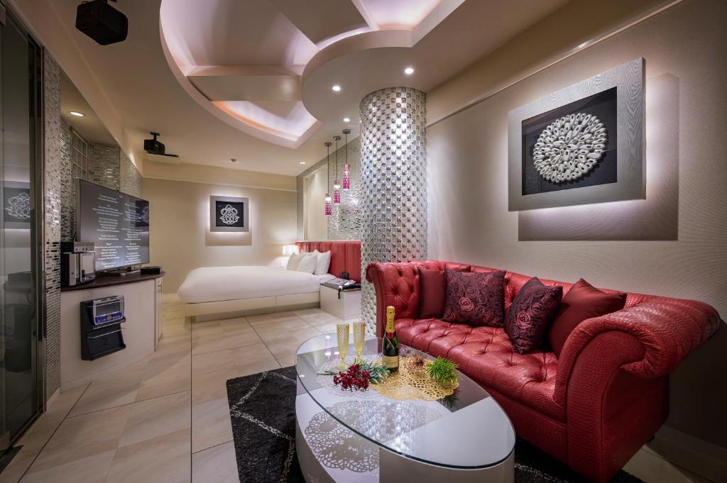 un salon avec un canapé rouge et une table dans l'établissement ホテルディオールセブン郡山, à Koriyama