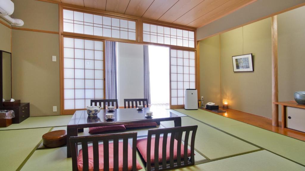 une salle à manger avec une table et des chaises dans l'établissement 汐の丸, à Imabari