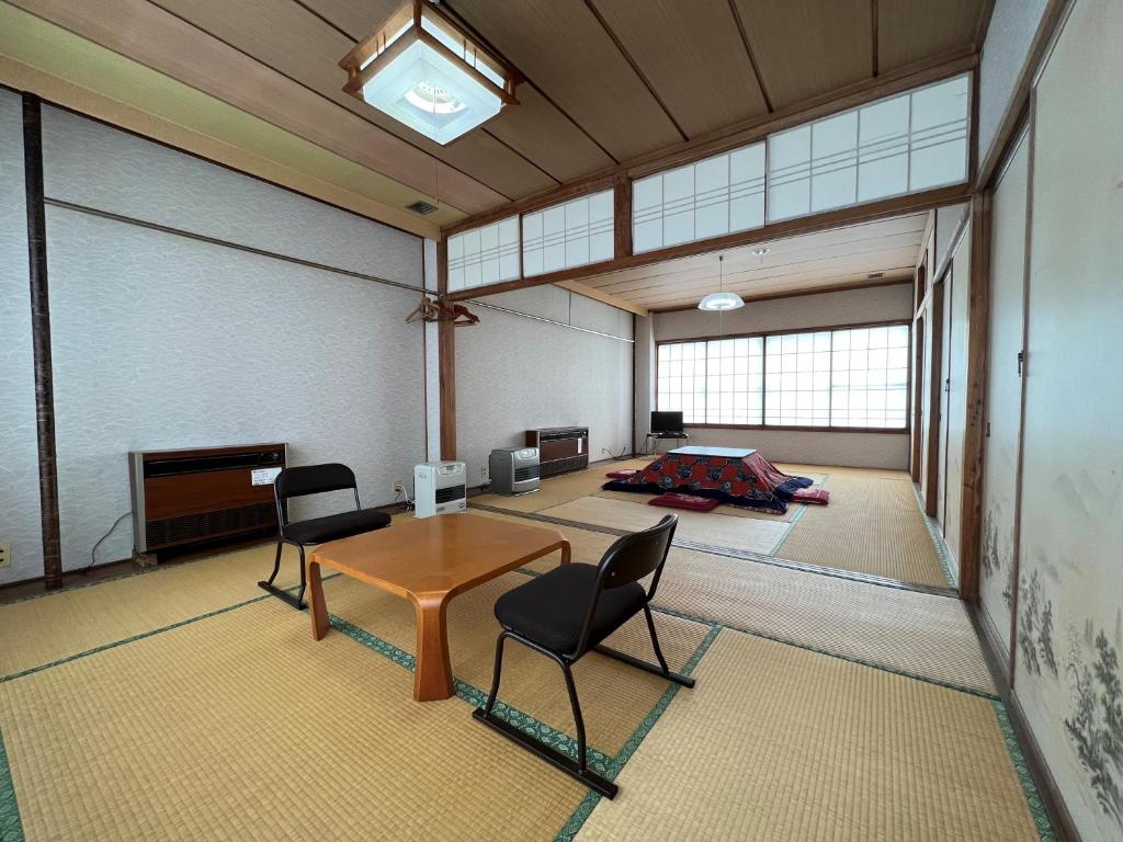 une grande pièce avec une table et des chaises dans l'établissement Akakura onsen eho ryokan, à Myōkō