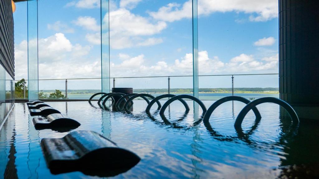 une piscine avec vue sur l'eau dans l'établissement KAMENOI HOTEL Itako, à Itako