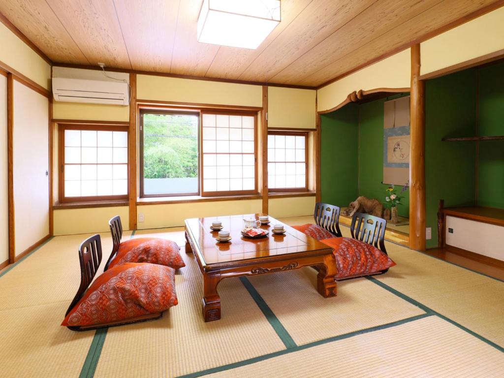 un salon avec une table et deux chaises dans l'établissement 和みの湯宿なかやま, à Komagane 65 autres photos