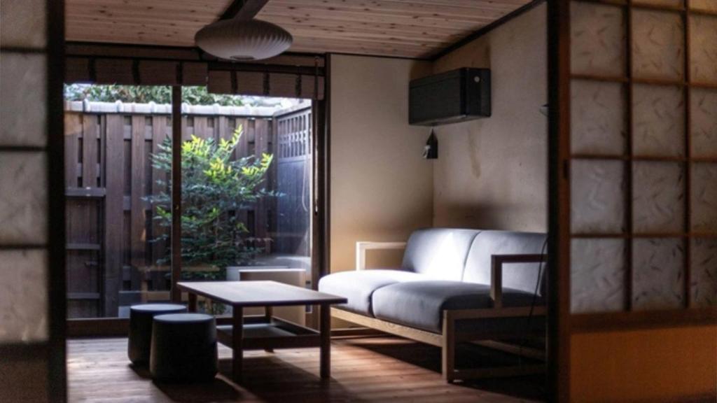 un salon avec un canapé et une table dans l'établissement NIPPONIA Sasayama Castle Town Hotel, à Sasayama