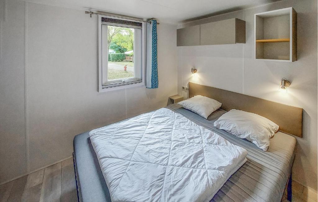 une chambre avec un grand lit avec une fenêtre dans l'établissement Mobile Home Moderne, à Saint-Hilaire-de-Talmont