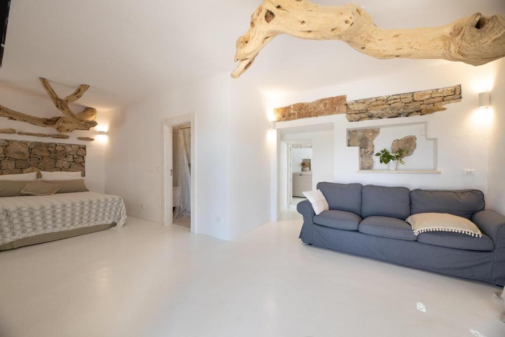 - un salon avec un canapé bleu et un lit dans l'établissement Villa Ametista, à Taviano